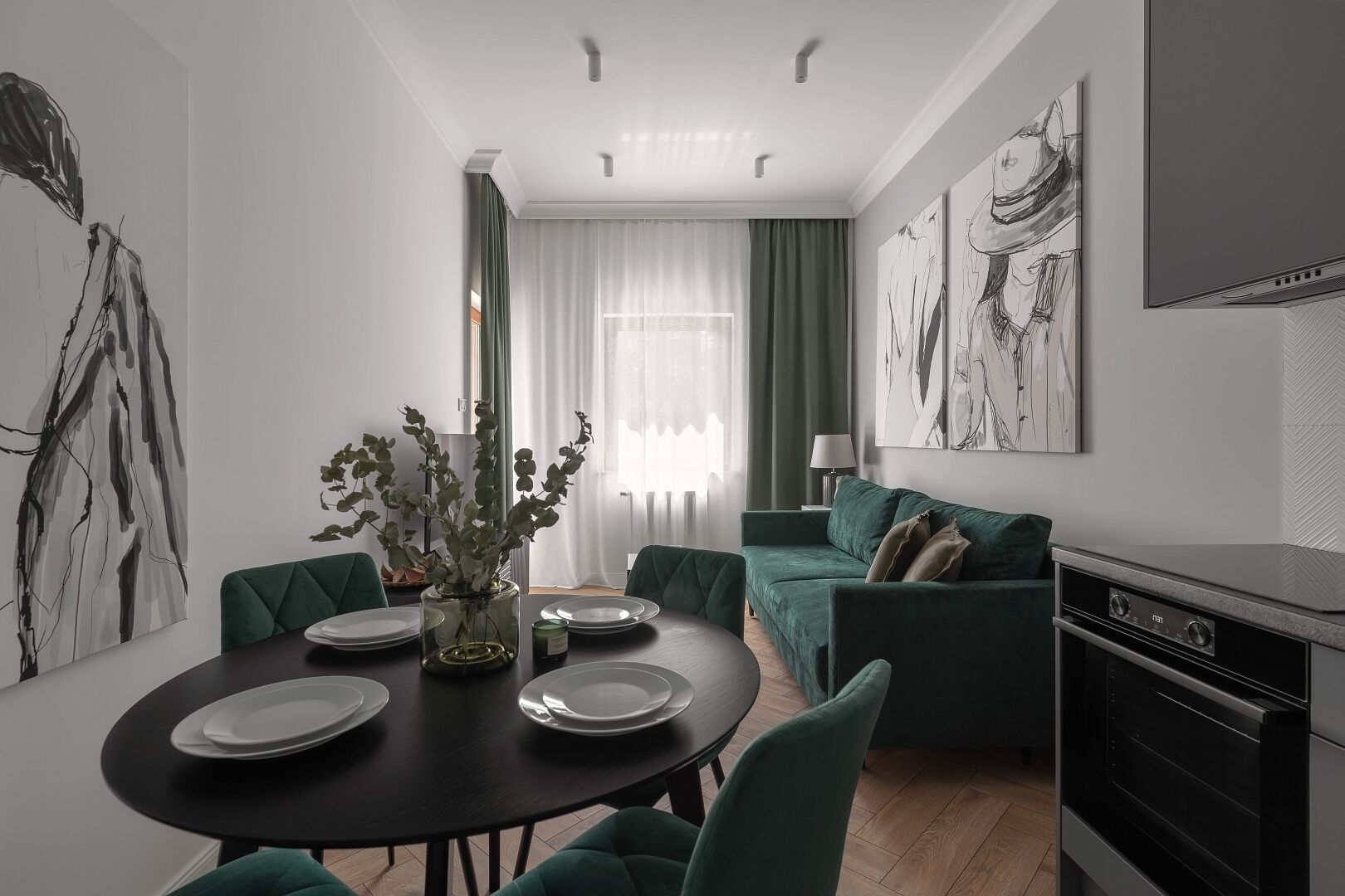 En moderne stue med spiseplads, grønne møbler og billedkunst på væggene.