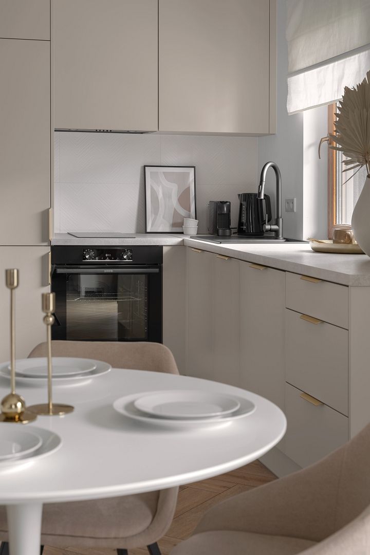 Een moderne keuken met witte kasten, een inbouwoven en een koffiezetapparaat.