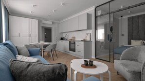 Una sala de estar moderna con un sofá, una mesa de comedor y una cocina con armarios y una estufa.