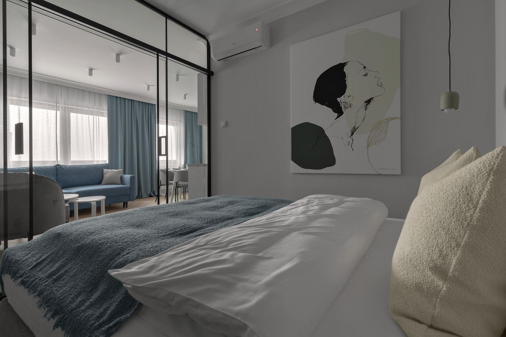 Ein modernes Hotelzimmer mit einem großen Bett, einem Schreibtisch, einer Couch und einem großen Fenster mit Vorhängen.