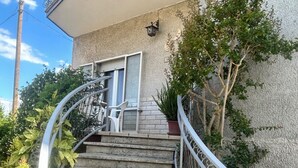 Un escalier avec des rampes en métal menant à l’entrée d’un bâtiment.