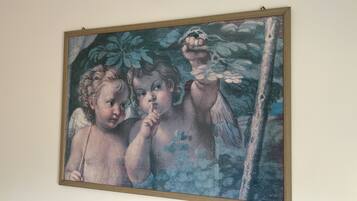 A framed painting of two children with a tree and a bird.