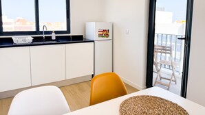 A modern kitchen with a sink, a refrigerator, and a window with a view of buildings. - BIA D'Olaf Apartments (Santa Maria)