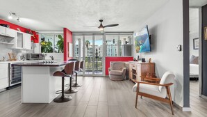 A modern kitchen with a central island, bar stools, and a dining area with a chair. - Tropical Escape With Pool Tennis Cabo Rojo (Cabo Rojo)