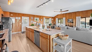 A modern kitchen with wooden cabinets, granite countertops, and a central island. - Secluded Shoreline Retreat (Saint Helena Island)