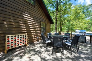 Eine Holzterrasse mit Gartenmöbeln und einem Grill.