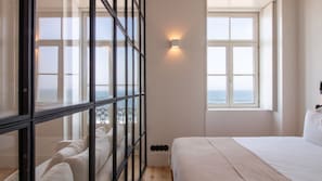 Una camera da letto con un'ampia finestra, un letto e vista mare.