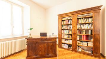 A room with a wooden desk, a bookshelf, and a window.