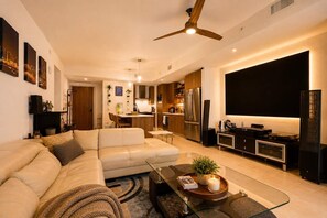 A modern living room with a sofa, coffee table, and TV stand.