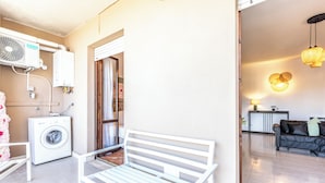 A living area with a white bench, a washing machine, and a ceiling fan. - Luxury Suite - Tentazioni Romantiche (Perugia)
