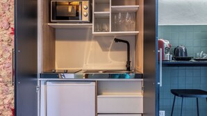 A compact kitchen with a microwave, wine glasses, and a sink. - Luxury Suite - Tentazioni Romantiche (Perugia)