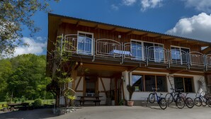Un bâtiment en bois doté d’un balcon, de vélos et d’une table de pique-nique.