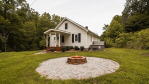 A house with a front porch, a fire pit in the yard, and a truck parked outside. - Shorty's Place | Hocking Hills, 80 Acres, Hot Tub (South Bloomingville)