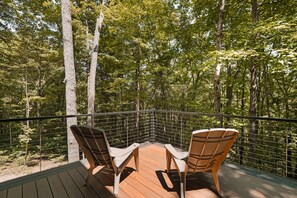 Une terrasse avec deux chaises donnant sur une zone boisée.