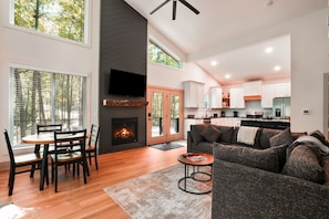 A modern kitchen with white cabinets, a built-in oven, and a large window. - Onyx Ridge | Hocking Hills, Luxury Cabin, Hot Tub (South Bloomingville)