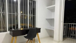A modern room with a black desk, a black chair, and a white tiled floor. - Spacious apartment in Palmira, peace (Palmira)