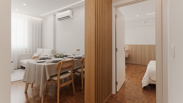 Ett modernt hotellrum med en matplats, träpanel och en säng.
