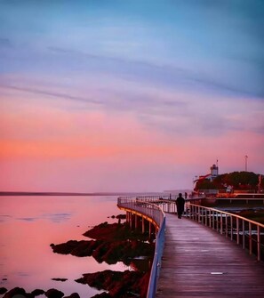 A wooden pier extending into calm waters at sunset. - Apulia Garden Barbecue Suite (Esposende)