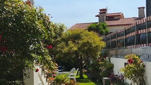 Un sendero en un jardín que conduce a un edificio con techo de tejas.