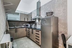 Frigorífico grande, microondas, placa de cocina y utensilios de cocina