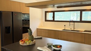 A modern kitchen with a central island, stainless steel appliances, and a window providing natural light.