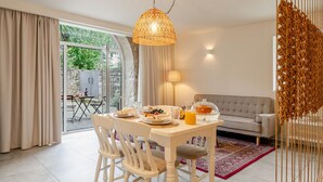 Uma sala de jantar moderna com uma mesa posta para o café da manhã, um sofá e vista para o exterior.