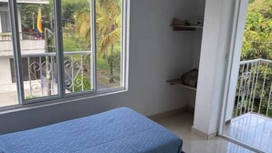 A room with a bed, a window with a view of greenery and a balcony. - Comfortable apartment in Palmira, fe (Palmira)