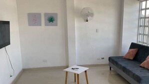 A living room with a white table, a grey sofa, and two wall-mounted fans. - Comfortable apartment in Palmira, fe (Palmira)