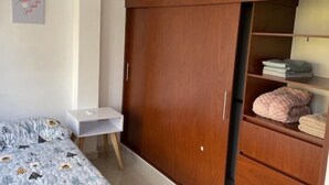 A bedroom with a bed, a desk, and a wardrobe with shelves. - Comfortable apartment in Palmira, fe (Palmira)