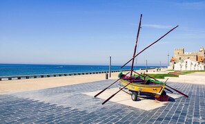 A colorful boat on a paved area near a body of water and a historic building. - 2 Floors Villa Close Ap lia Beach (Esposende)