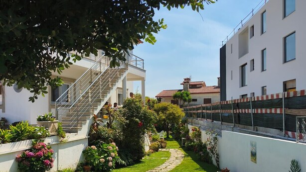 A well-maintained garden with a stone pathway leading to a building with a staircase. - 300m by Ap lia Beach Terrace (Esposende)