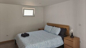 A bedroom with a bed, a nightstand, a lamp, and a window. - 300m by Ap lia Beach Terrace (Esposende)
