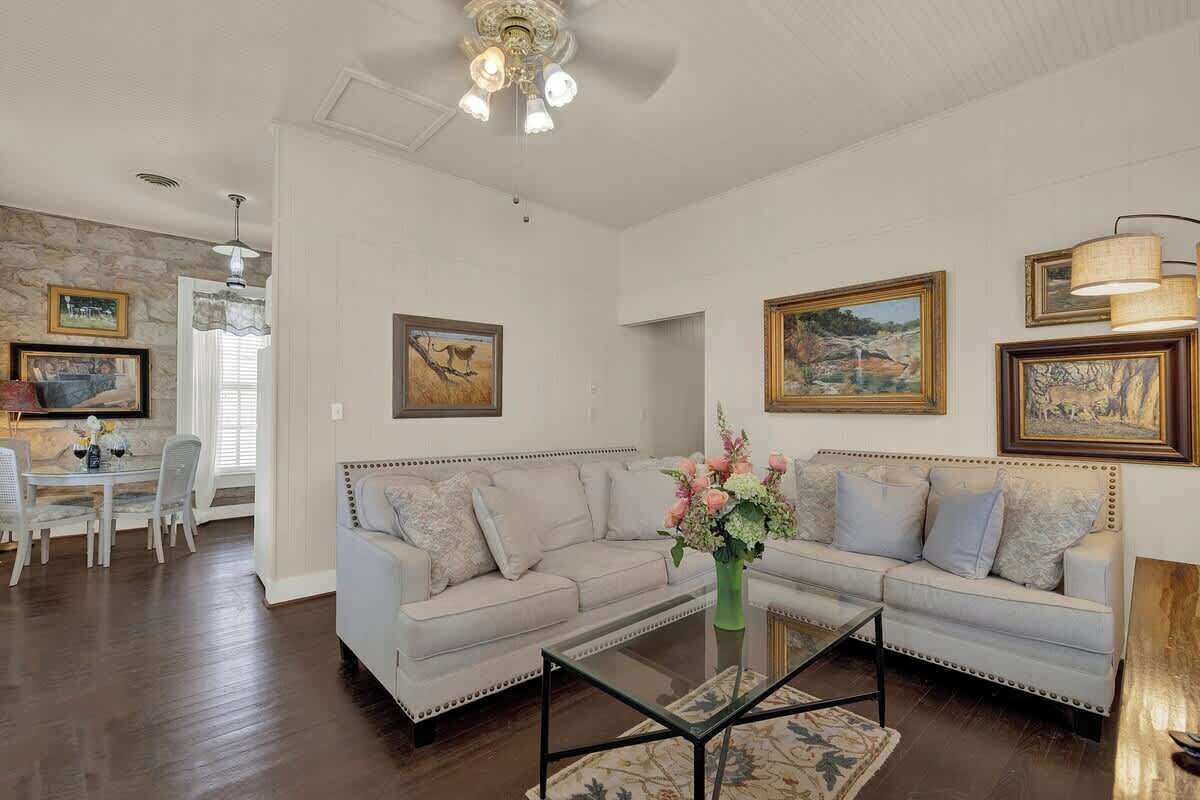 A living room with a sofa, coffee table, and artwork on the walls.