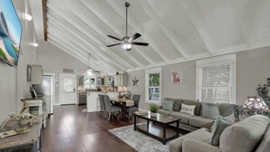 A spacious living room with a high ceiling, a dining area, and a kitchen. - Charming Cottage-3 Mins to Downtown-pet Friendly! (Fredericksburg)