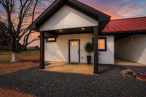 A modern building with a white facade, black trim, and a red roof. - Cozy Casita With Hot Tub Six Minutes From Main Street (Fredericksburg)