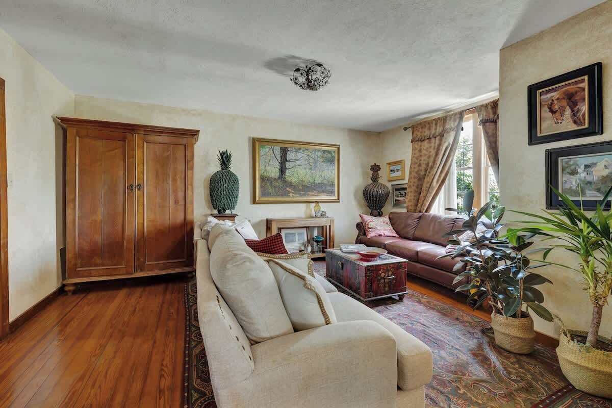 A living room with a sofa, a wooden cabinet, a coffee table, and a rug.