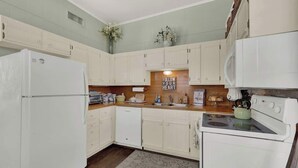 A kitchen with white cabinets, a refrigerator, a dishwasher, and a stove. - Fountain Suite-stay Right on Historic Main Street in the Heart of Fredericksburg (Fredericksburg)