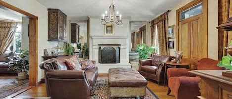 A traditional living room with a fireplace, leather furniture, and a patterned rug.