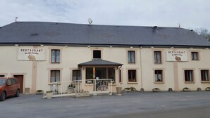 Un bâtiment à deux étages, sur lequel on peut lire l’inscription « RESTAURANT » et qui arbore un logo représentant un lapin.