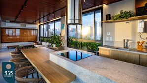 A modern kitchen with a large island, wooden ceiling, and city views. - Unforgettable stay between Farol and Barra Mall (Salvador)