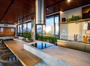 A modern kitchen with a large island, wooden ceiling, and city views. - Unforgettable stay between Farol and Barra Mall (Salvador)
