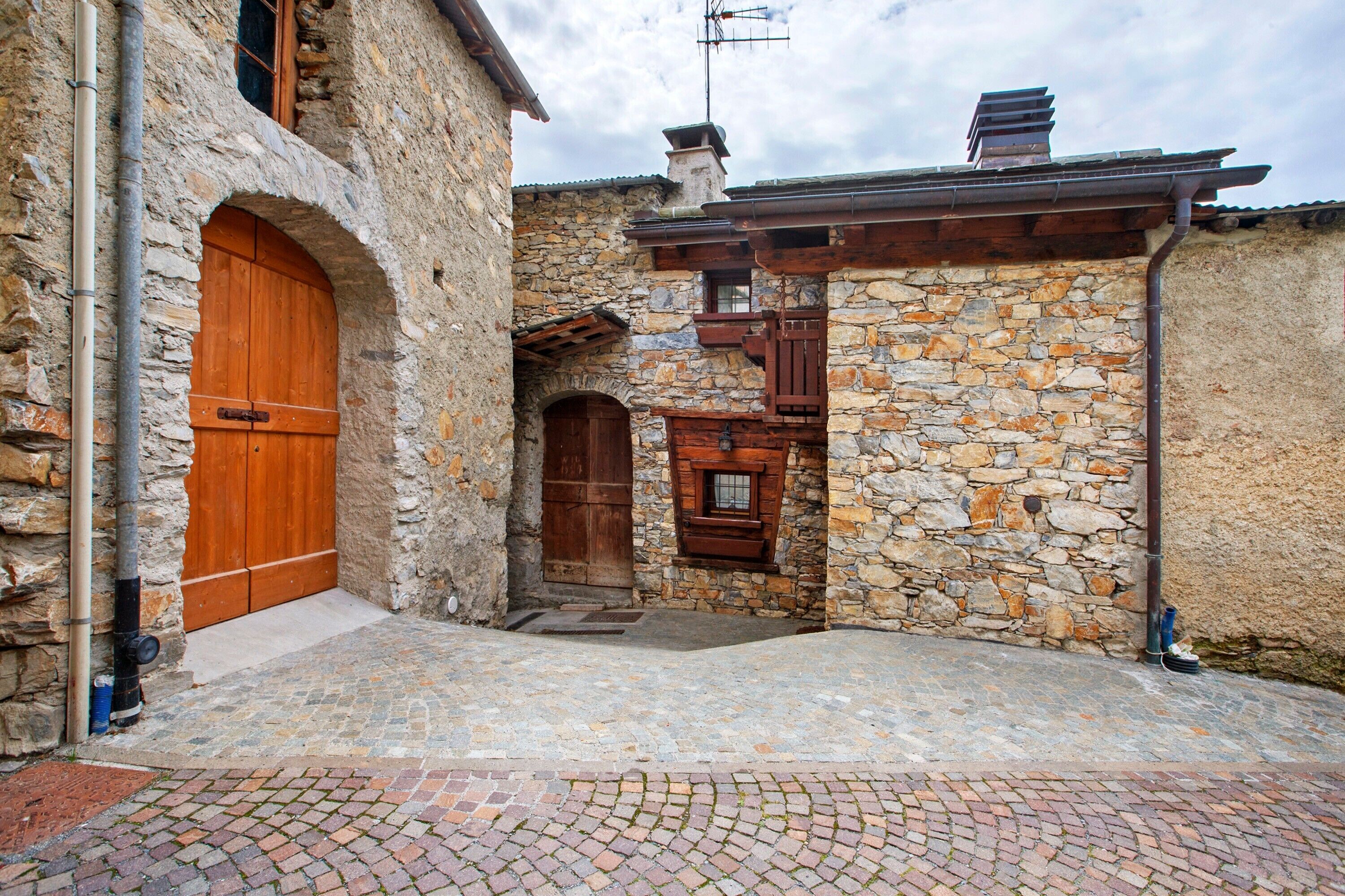 Un bâtiment en pierre avec une porte en bois et une petite fenêtre.