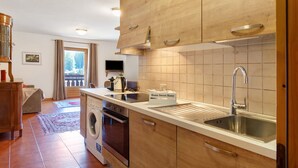 Een moderne keuken met houten kastjes, een roestvrijstalen spoelbak en een inbouwoven.