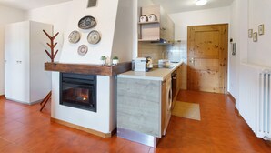Een moderne keuken met een ingebouwde oven, een houten aanrechtblad en een decoratief object aan de muur.