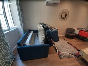 Une pièce comprenant un lit, une table et une chaise.