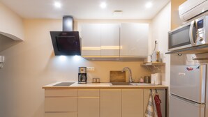 Une cuisine moderne équipée d’un four à micro-ondes encastré, d’une machine à café et d’appareils électroménagers en acier inoxydable.