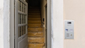 Un escalier menant à une porte dotée d’un clavier à code de sécurité fixé au mur.