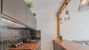 A modern kitchen with a wooden countertop, black backsplash, and a built-in stove.