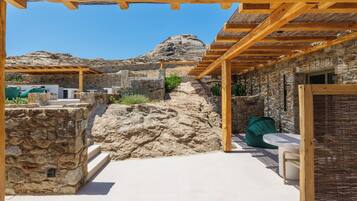 A stone building with a wooden pergola and outdoor seating area.