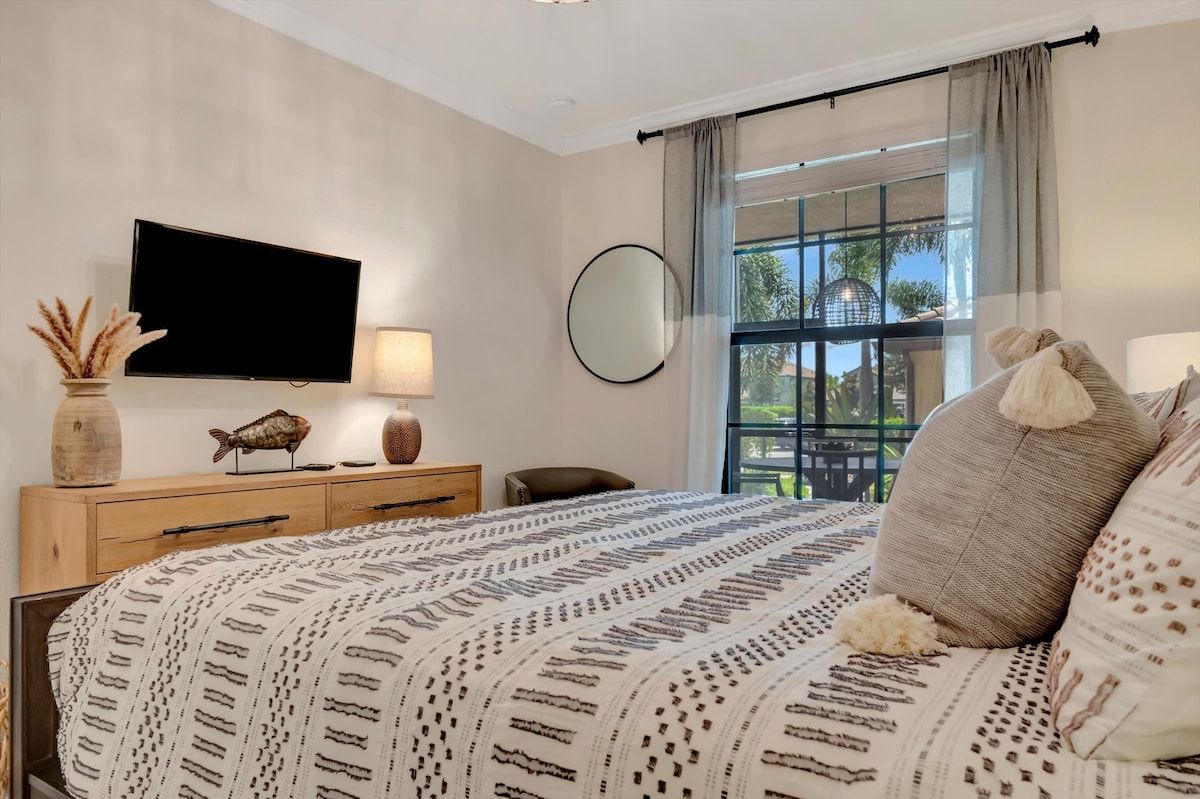 Sink into plush bedding and wake to gentle natural light filtering through your window, with a peaceful view of palm trees and greenery welcoming you to each Florida morning.